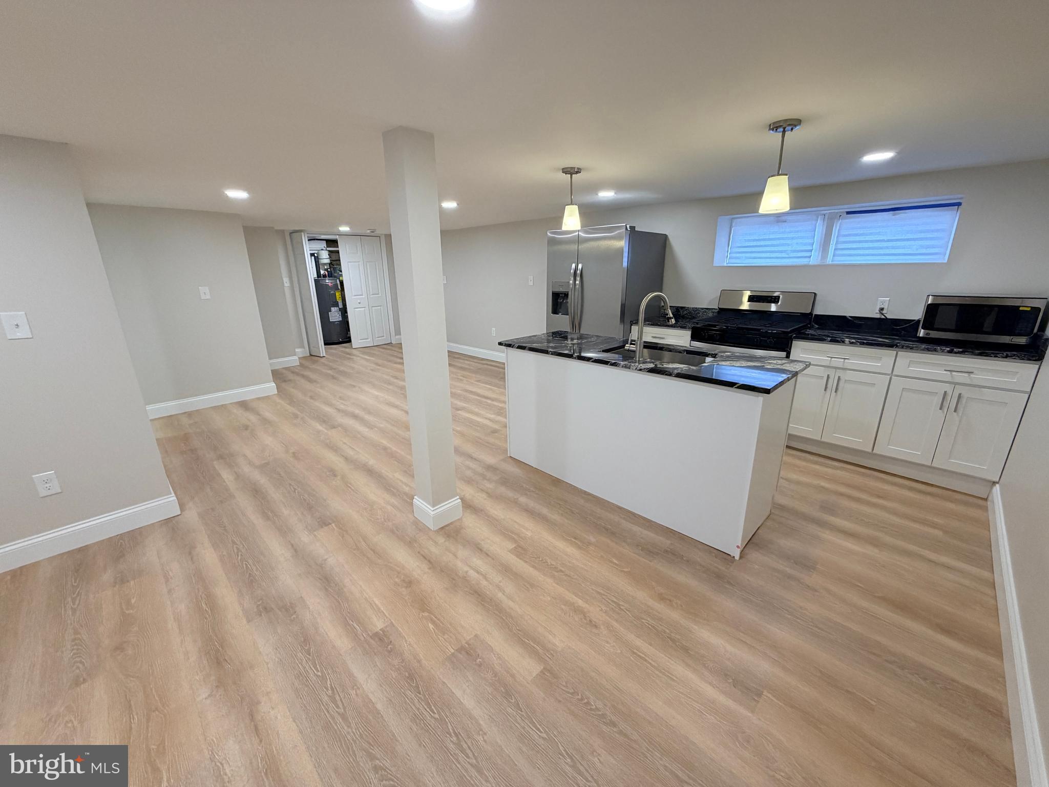 3 East Overlea Avenue, Unit 3 Baltimore, MD 21206 - Photo 11 of 45 a large kitchen with stainless steel appliances kitchen island a sink dishwasher a refrigerator and a microwave oven