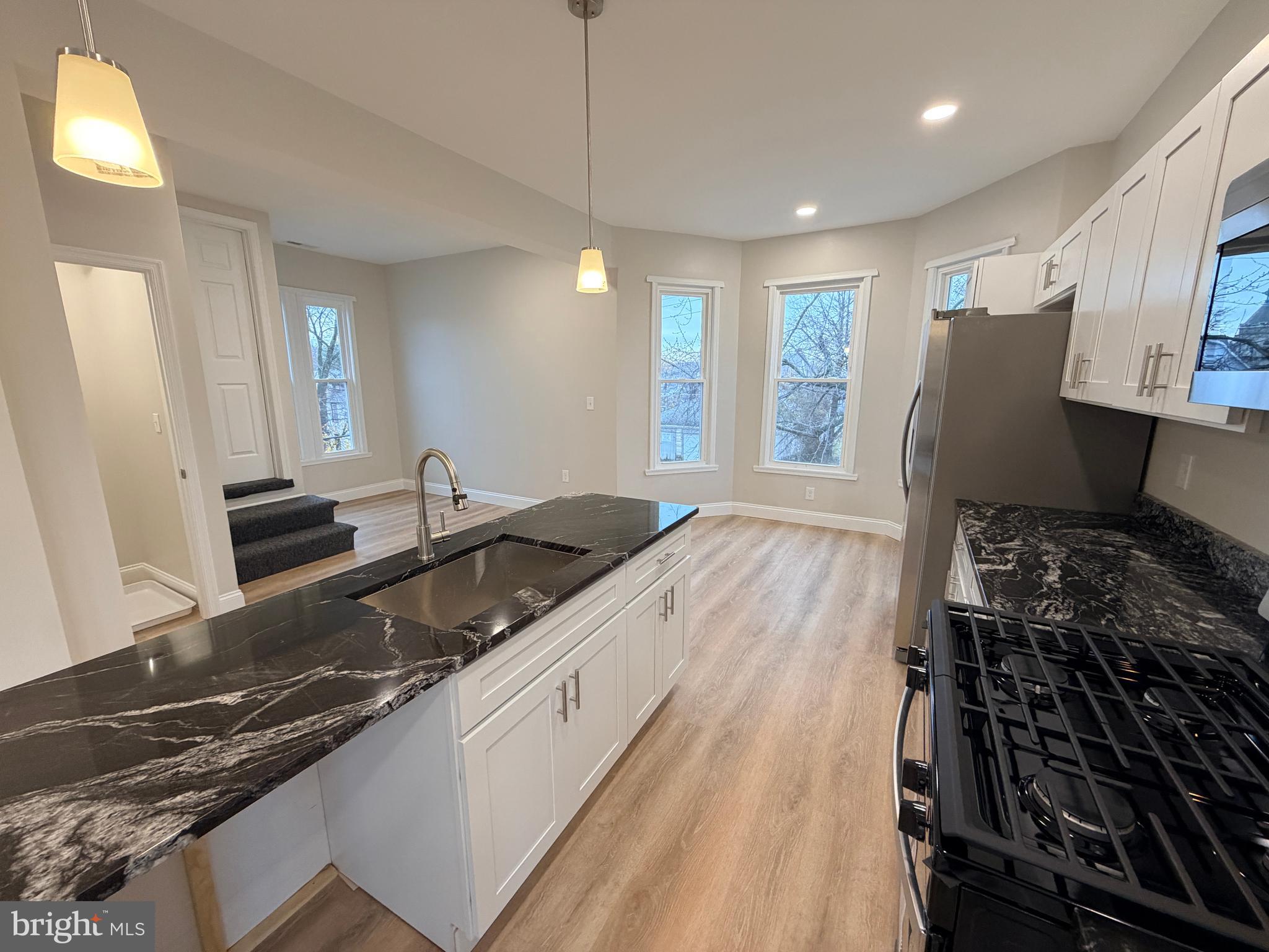 3 East Overlea Avenue, Unit 3 Baltimore, MD 21206 - Photo 14 of 45 a large kitchen with granite countertop a stove and a sink