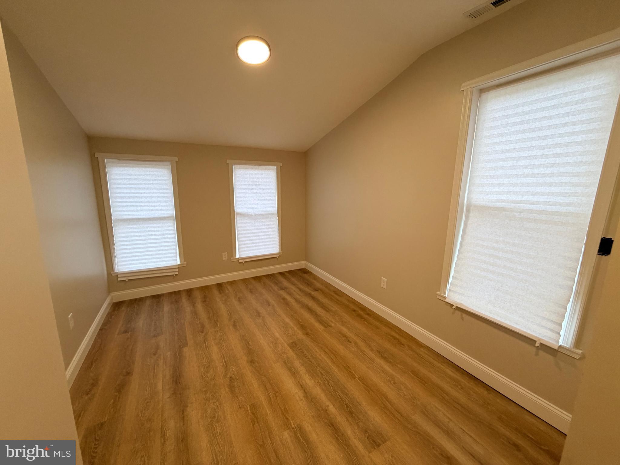 3 East Overlea Avenue, Unit 3 Baltimore, MD 21206 - Photo 42 of 45 an empty room with wooden floor and windows