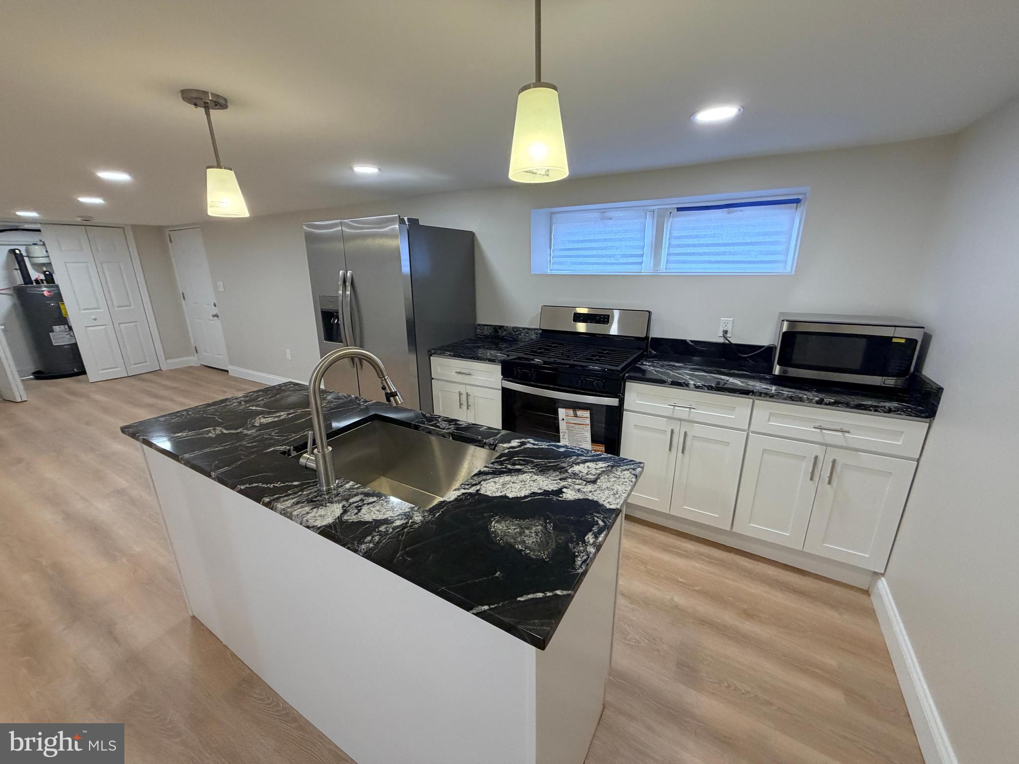 3 East Overlea Avenue, Unit 3 Baltimore, MD 21206 - Photo 7 of 45 a kitchen with stainless steel appliances granite countertop a sink a stove a refrigerator and a oven with wooden floor