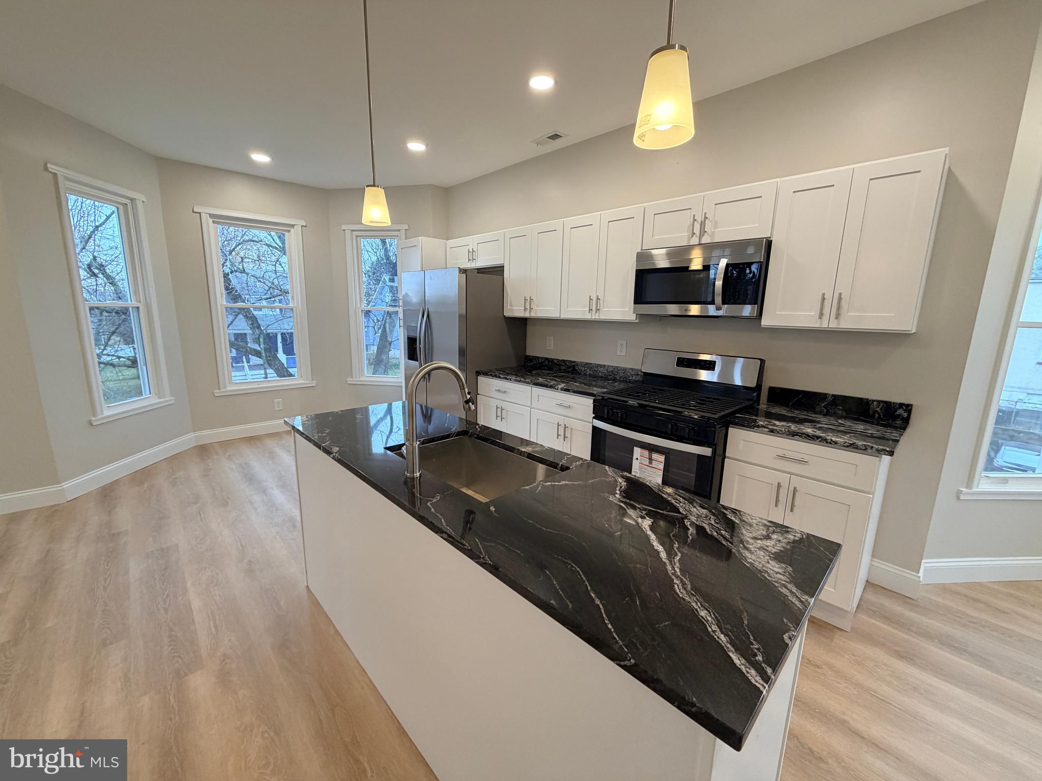 3 East Overlea Avenue, Unit 3 Baltimore, MD 21206 - Photo 10 of 45 a kitchen with stainless steel appliances granite countertop a sink a stove top oven a counter space and cabinets