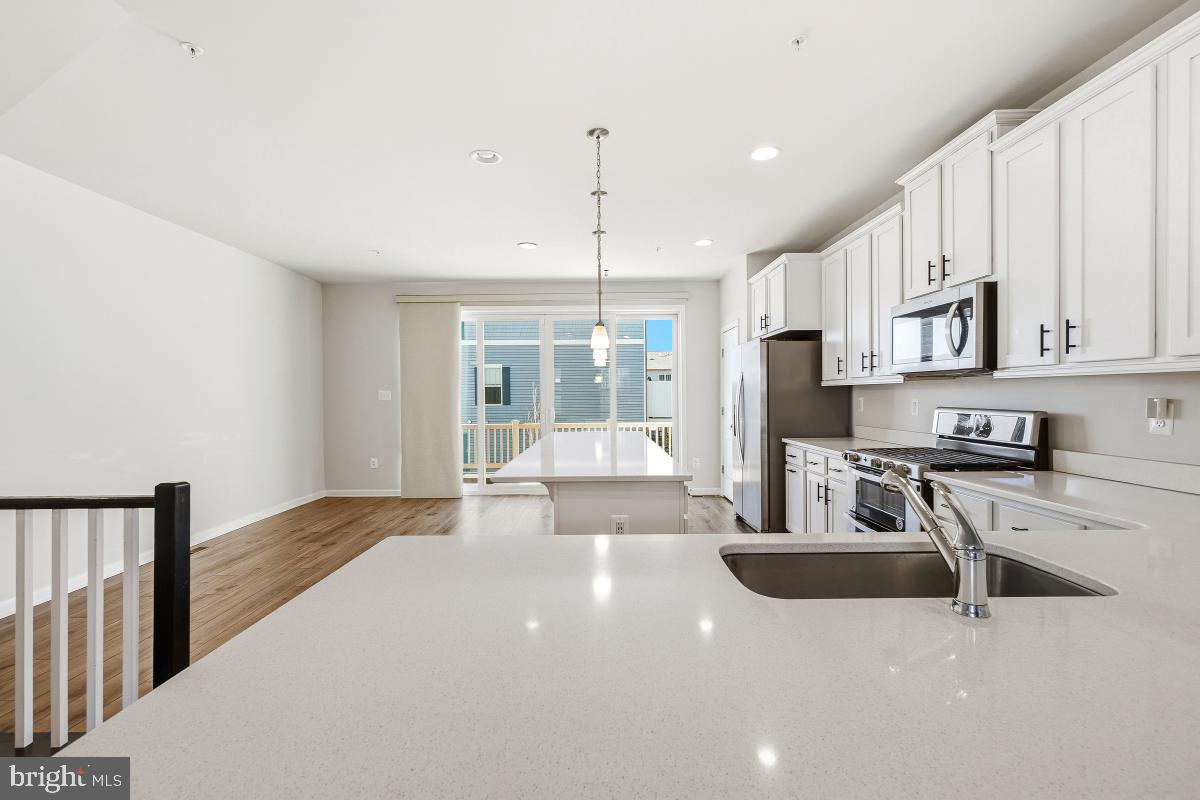 5820 Imperial Drive Frederick, MD 21703 - Photo 9 of 30 a kitchen with stainless steel appliances granite countertop a stove a sink dishwasher a refrigerator and white cabinets with wooden floor