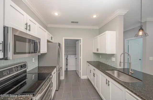 a kitchen with stainless steel appliances granite countertop a stove and a wooden floors