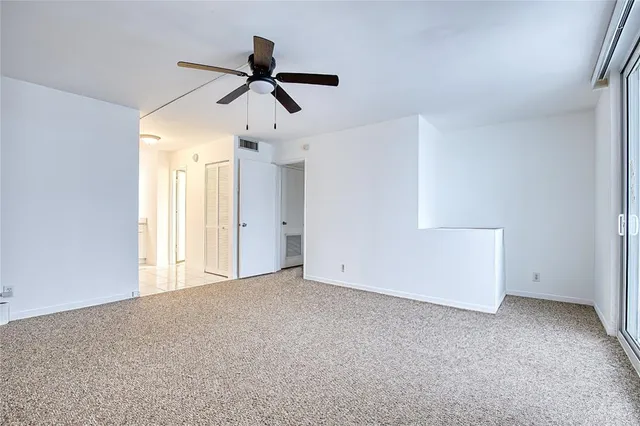 a view of empty room with ceiling fan