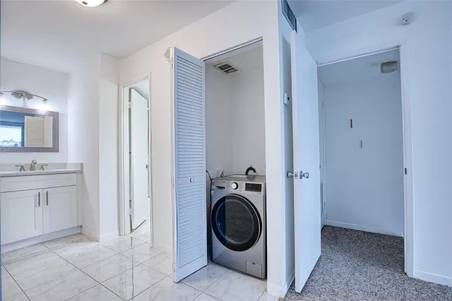 a view of a bathroom with washing machine and sink