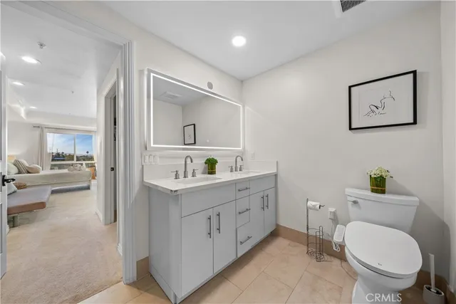 a spacious bathroom with a toilet a sink and mirror