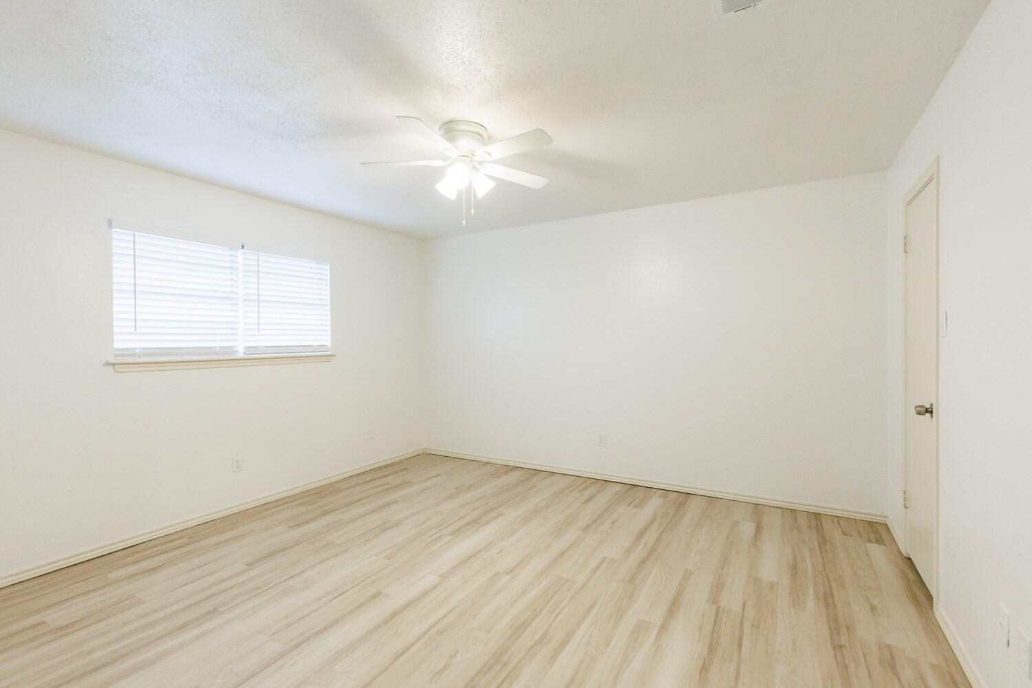 4407 75th Drive, Unit B Lubbock, TX 79424 - Photo 12 of 20 an empty room with wooden floor and windows
