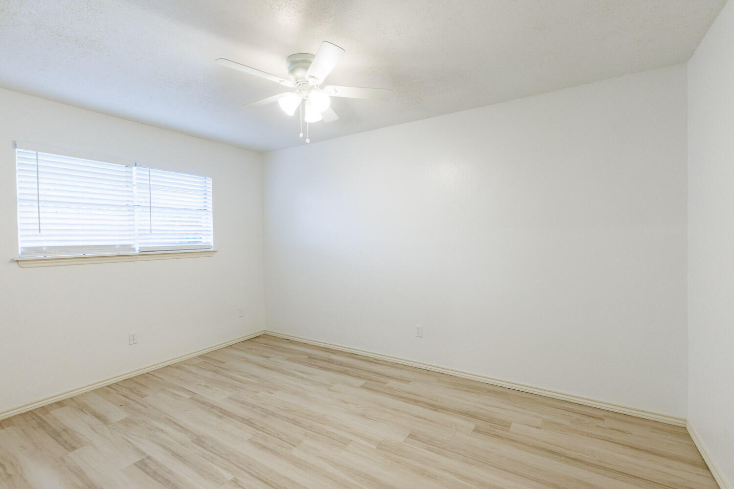 4407 75th Drive, Unit B Lubbock, TX 79424 - Photo 16 of 20 an empty room with wooden floor and windows