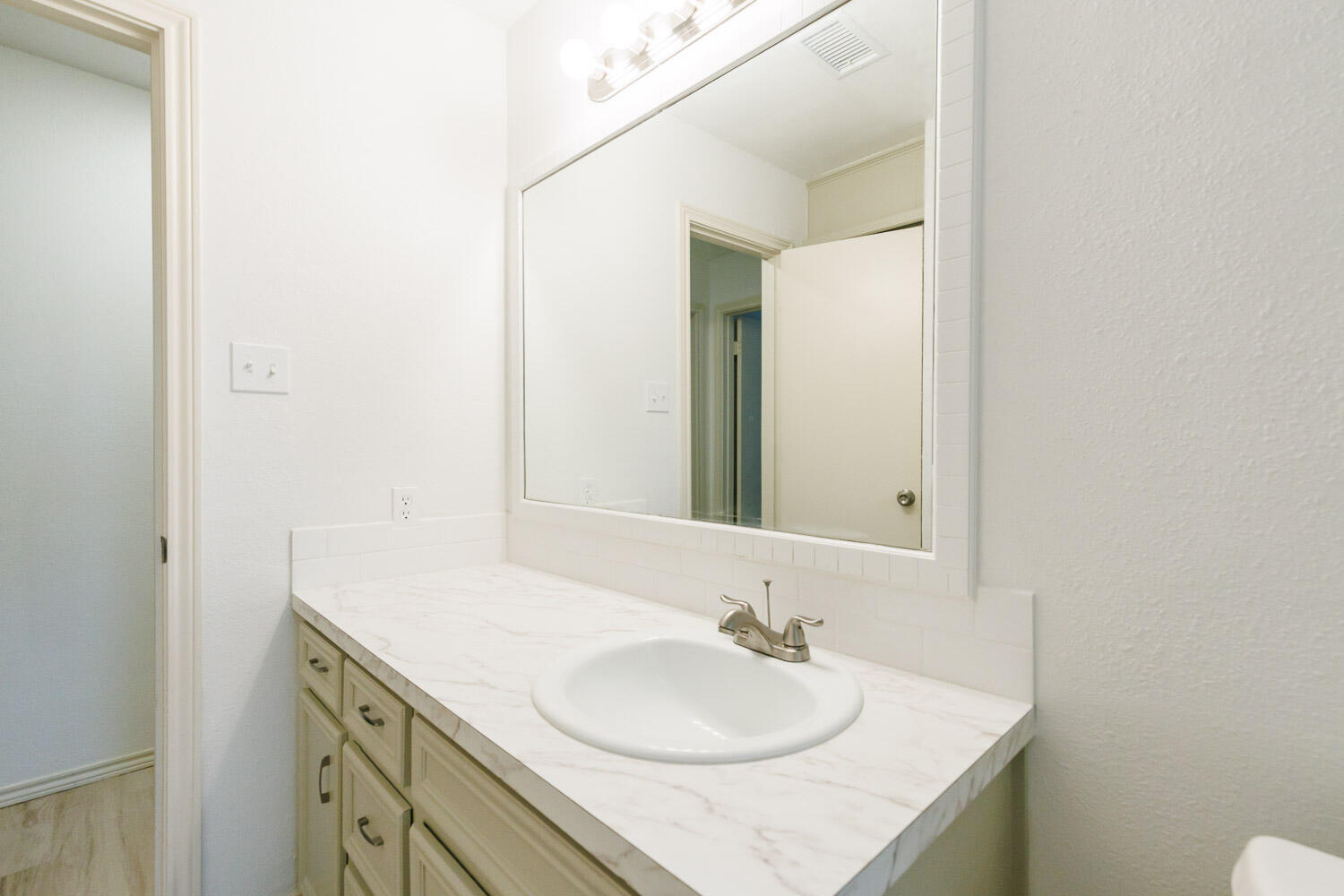 4407 75th Drive, Unit B Lubbock, TX 79424 - Photo 18 of 20 a bathroom with a granite countertop sink and a mirror
