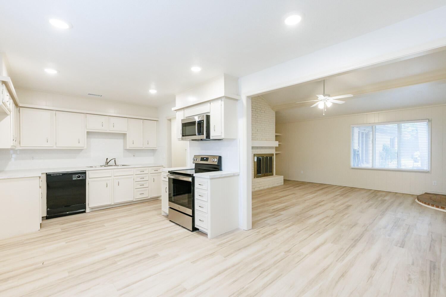 4407 75th Drive, Unit B Lubbock, TX 79424 - Photo 9 of 20 a view of a kitchen with a sink and dishwasher a stove top oven with wooden floor
