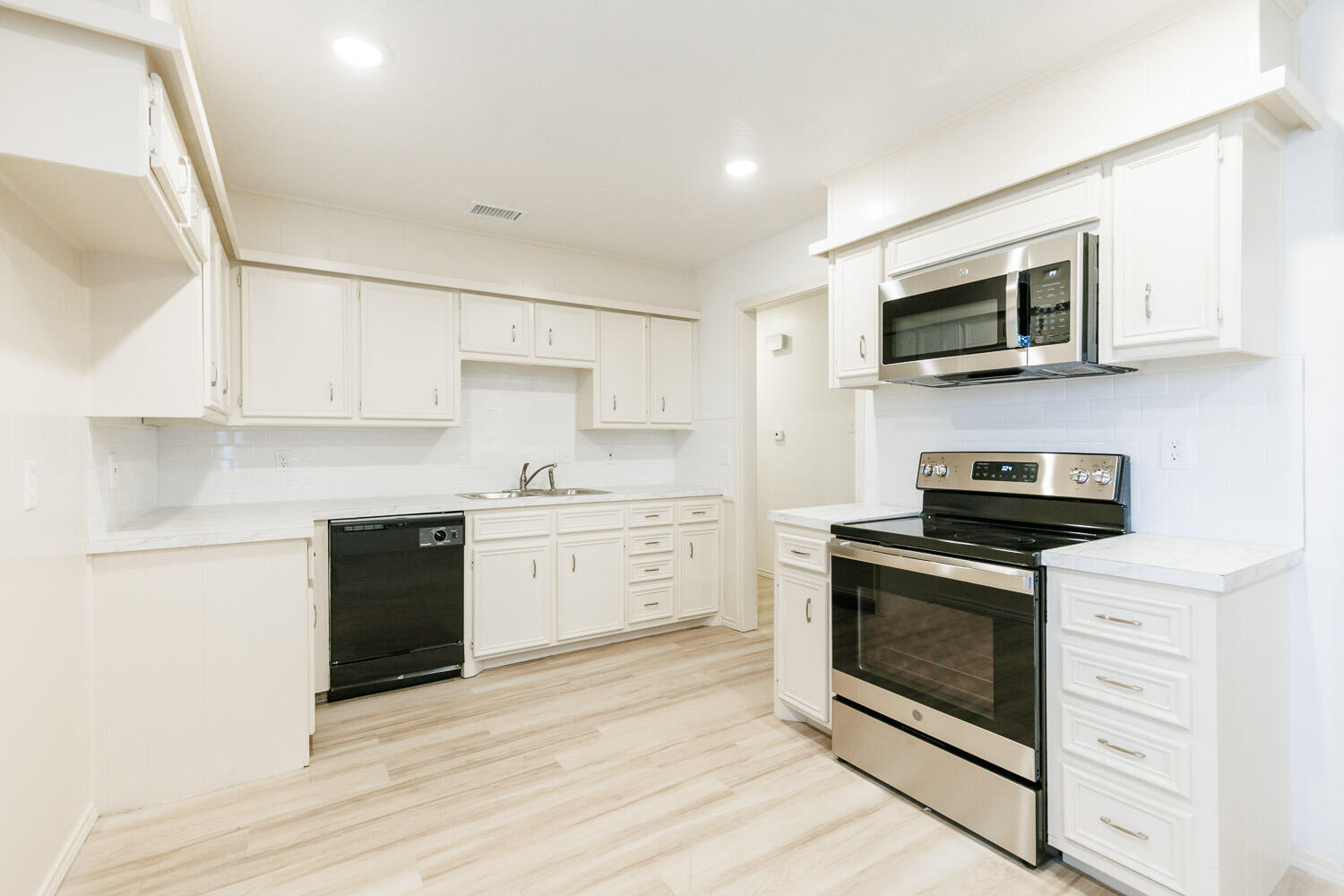 4407 75th Drive, Unit B Lubbock, TX 79424 - Photo 10 of 20 a kitchen with stainless steel appliances white cabinets and a stove top oven