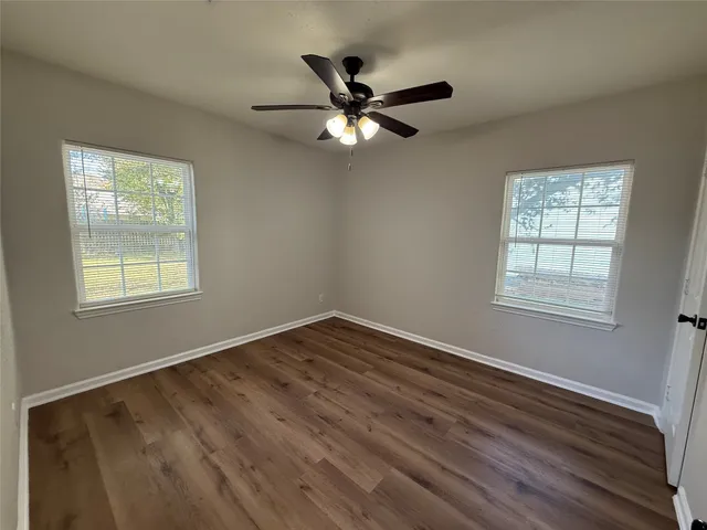 a view of wooden floor and a chandelier fan in a room