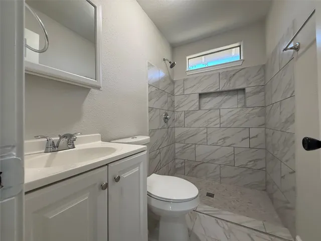 a bathroom with a sink a toilet and shower