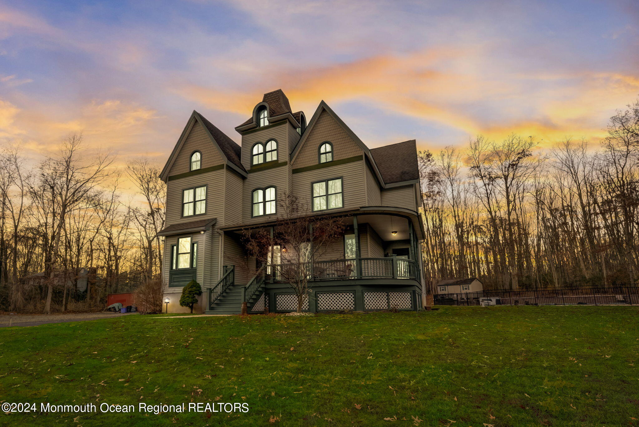 a view of a big house with a big yard and large trees