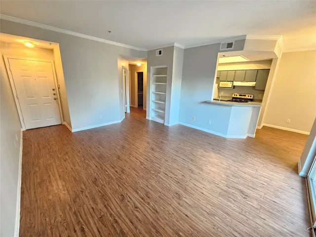 a view of a hallway with wooden floor and a bathroom