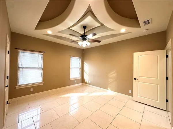 a view of a livingroom with a chandelier fan and windows