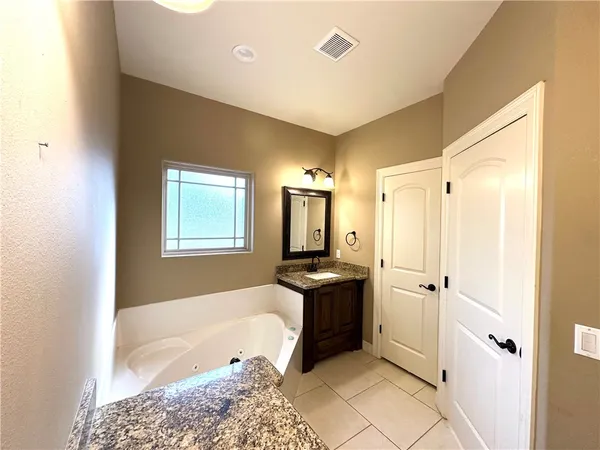 a bathroom with a tub sink and mirror