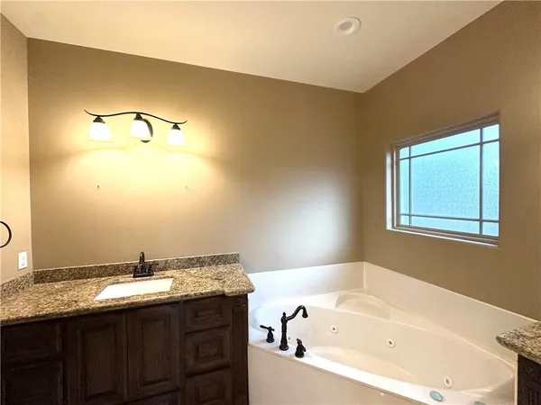 a bathroom with a tub sink and mirror