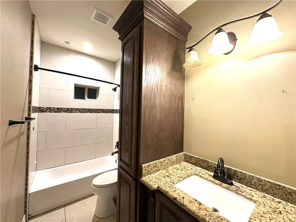 a bathroom with a granite countertop sink toilet and shower