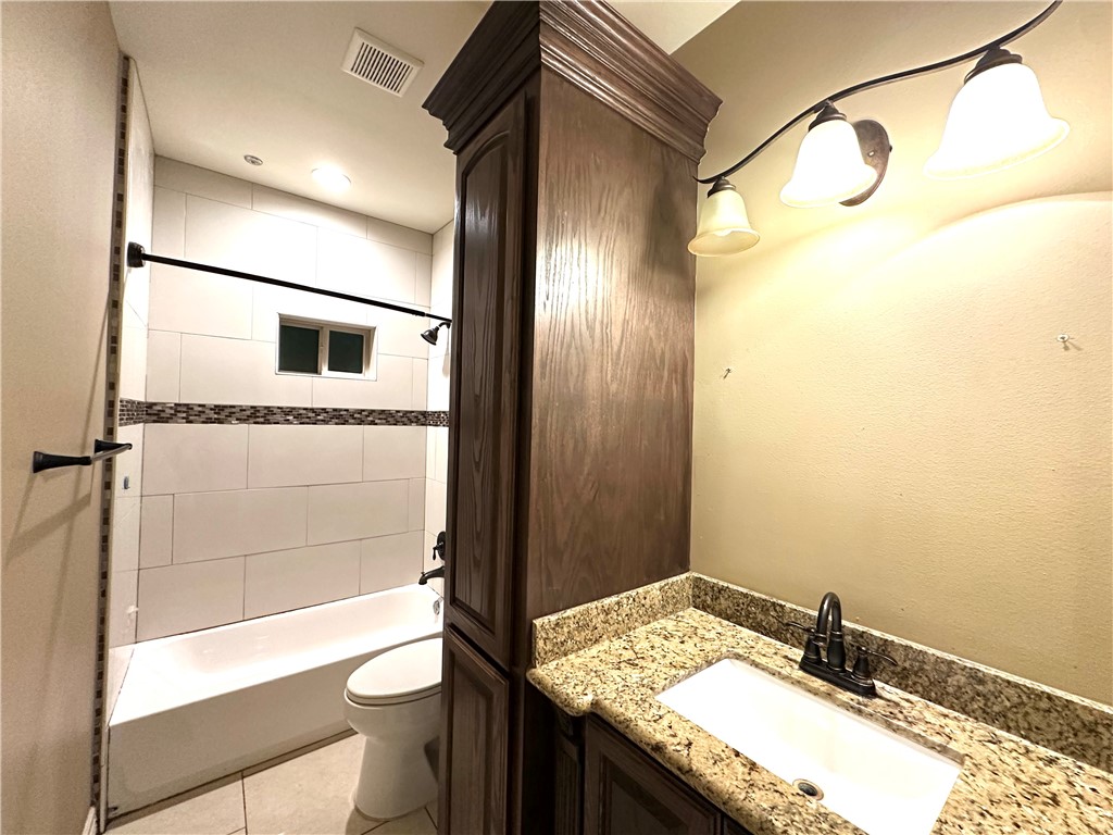 1503 Lewis Street Kingsville, TX 78363 - Photo 21 of 30 a bathroom with a granite countertop sink toilet and shower