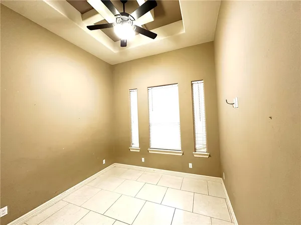 a view of an empty room and window with a fan