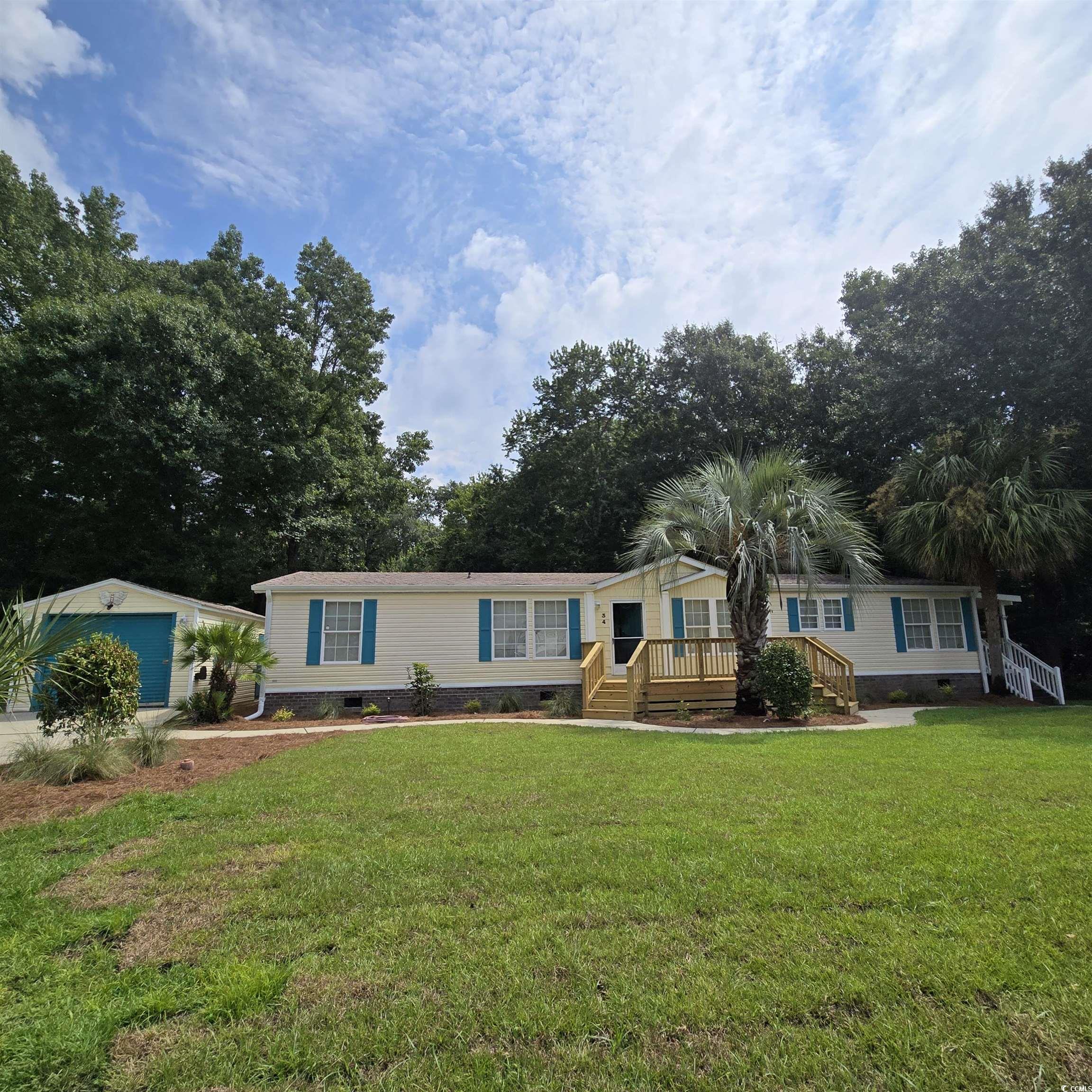 34 Talon Circle Murrells Inlet, SC 29576 - Photo 1 of 40 Manufactured / mobile home with crawl space, a front yard, a garage, stairs, and a wooden deck