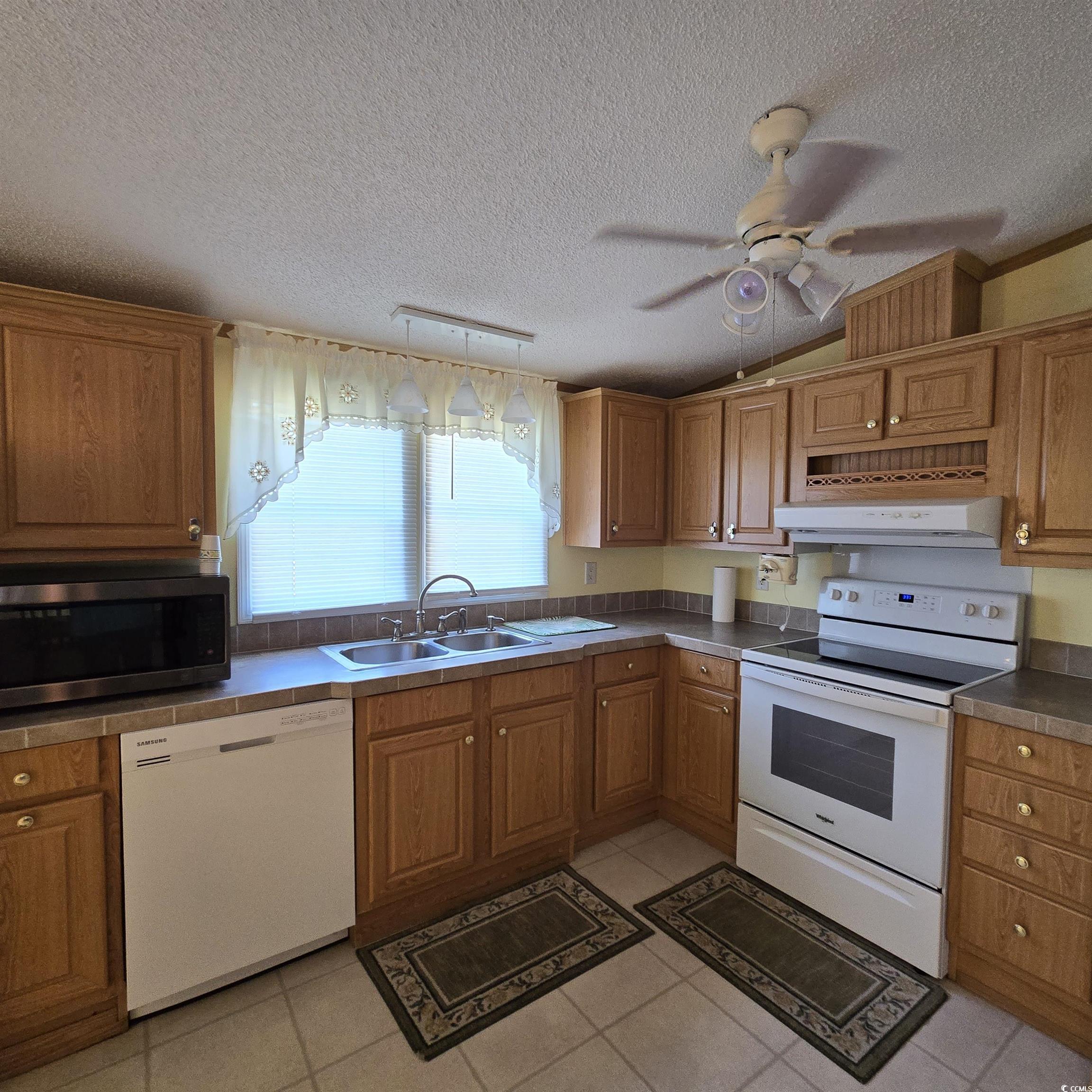 34 Talon Circle Murrells Inlet, SC 29576 - Photo 16 of 40 Kitchen with white appliances, vaulted ceiling, a ceiling fan, a textured ceiling, and ventilation hood