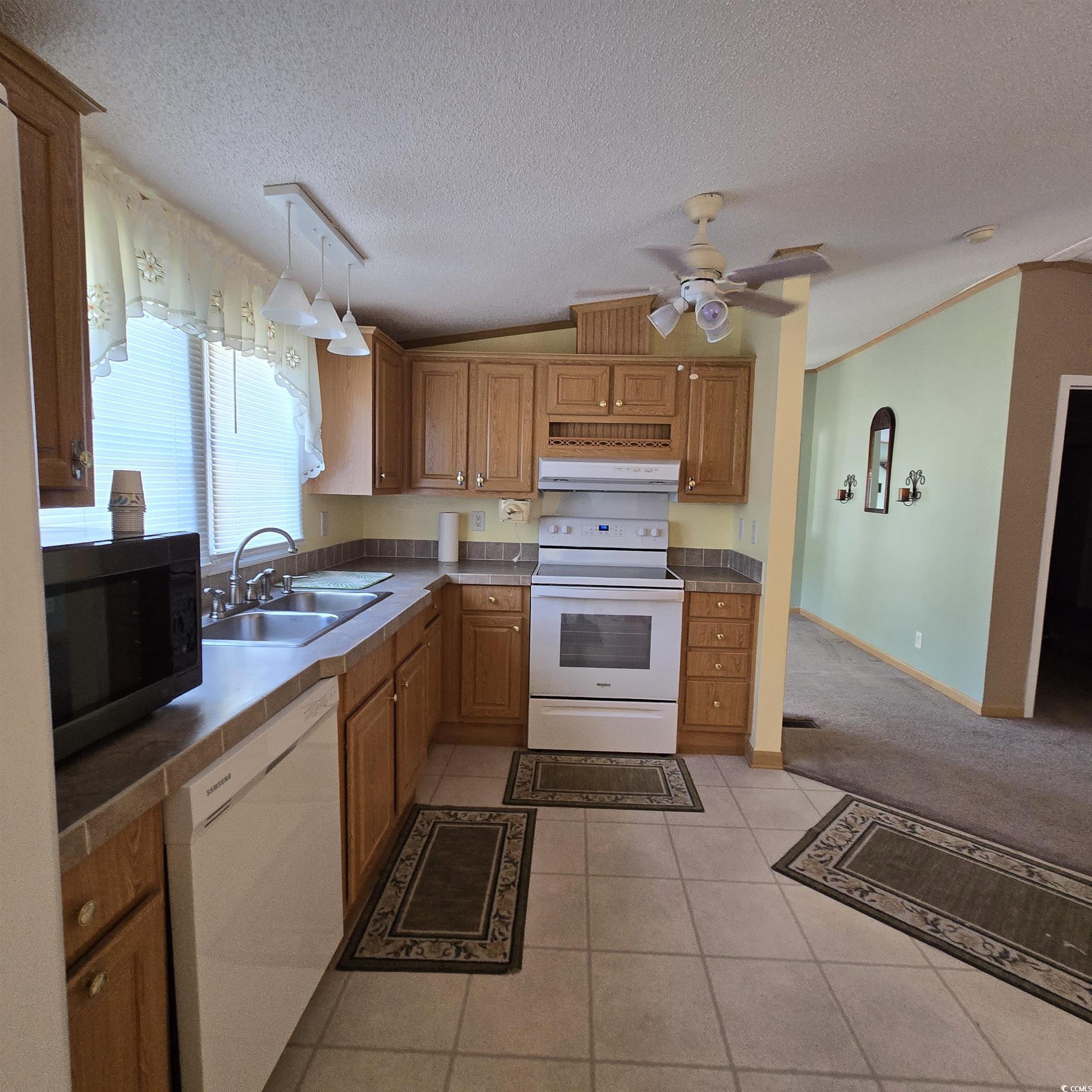 34 Talon Circle Murrells Inlet, SC 29576 - Photo 17 of 40 Kitchen with light tile patterned floors, vaulted ceiling, white appliances, a textured ceiling, and a ceiling fan