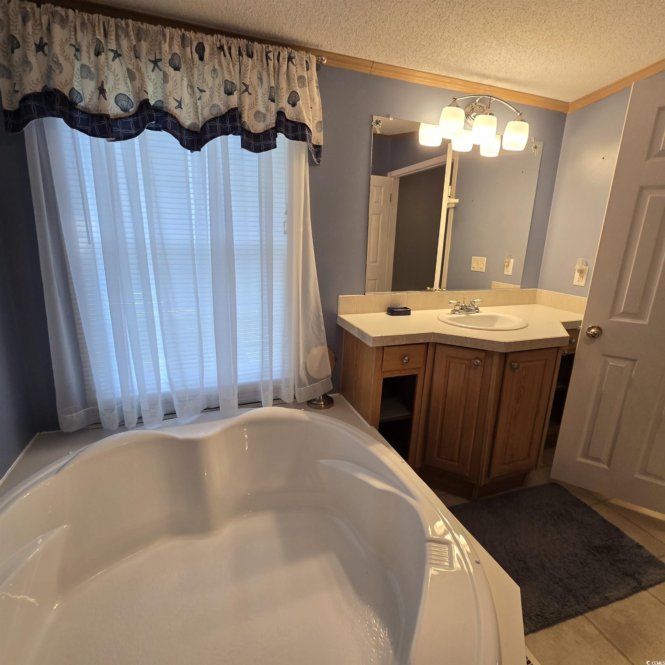 34 Talon Circle Murrells Inlet, SC 29576 - Photo 23 of 40 Full bath with vanity, a bathtub, a textured ceiling, ornamental molding, and a chandelier