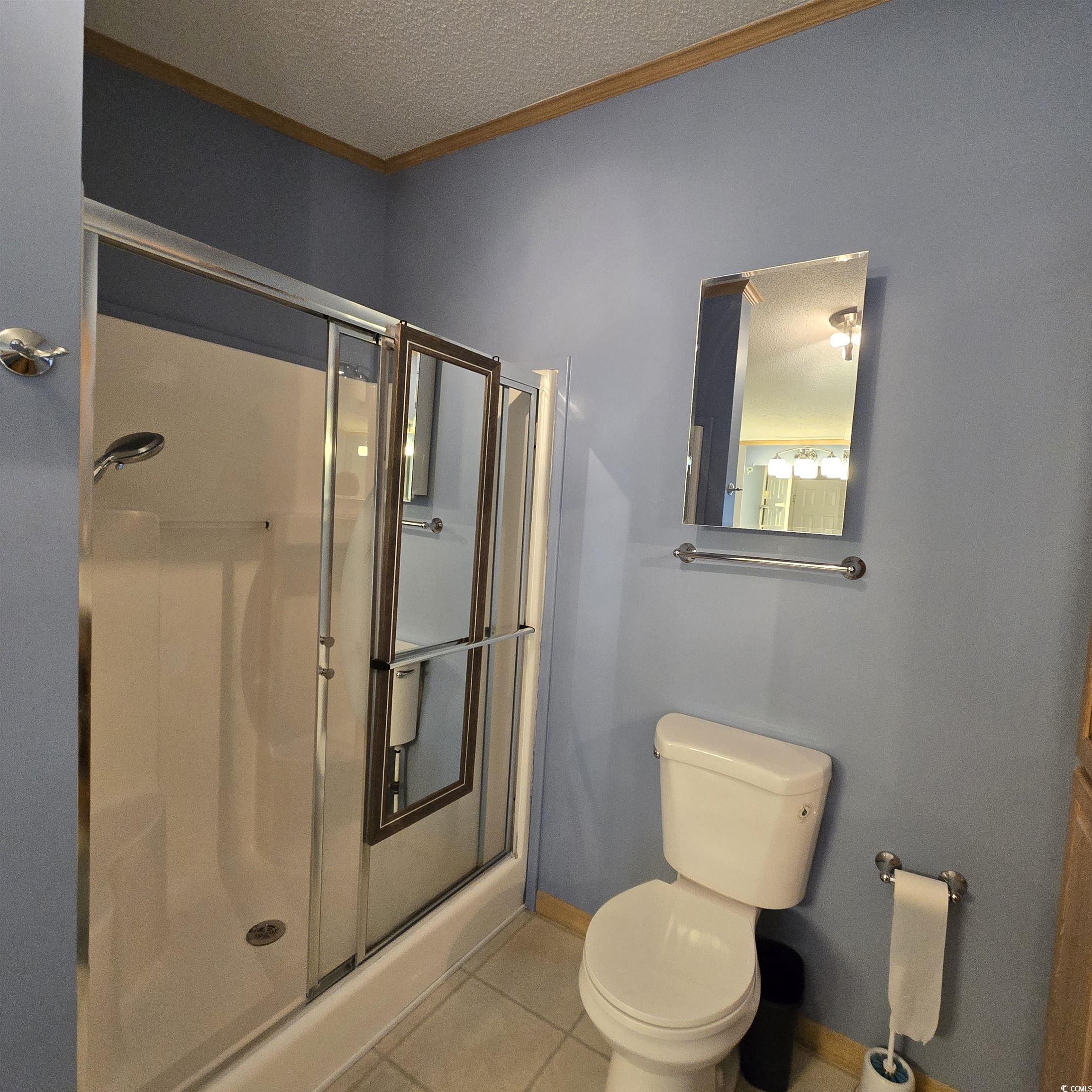 34 Talon Circle Murrells Inlet, SC 29576 - Photo 26 of 40 Full bath with tile patterned flooring, a stall shower, a textured ceiling, and ornamental molding