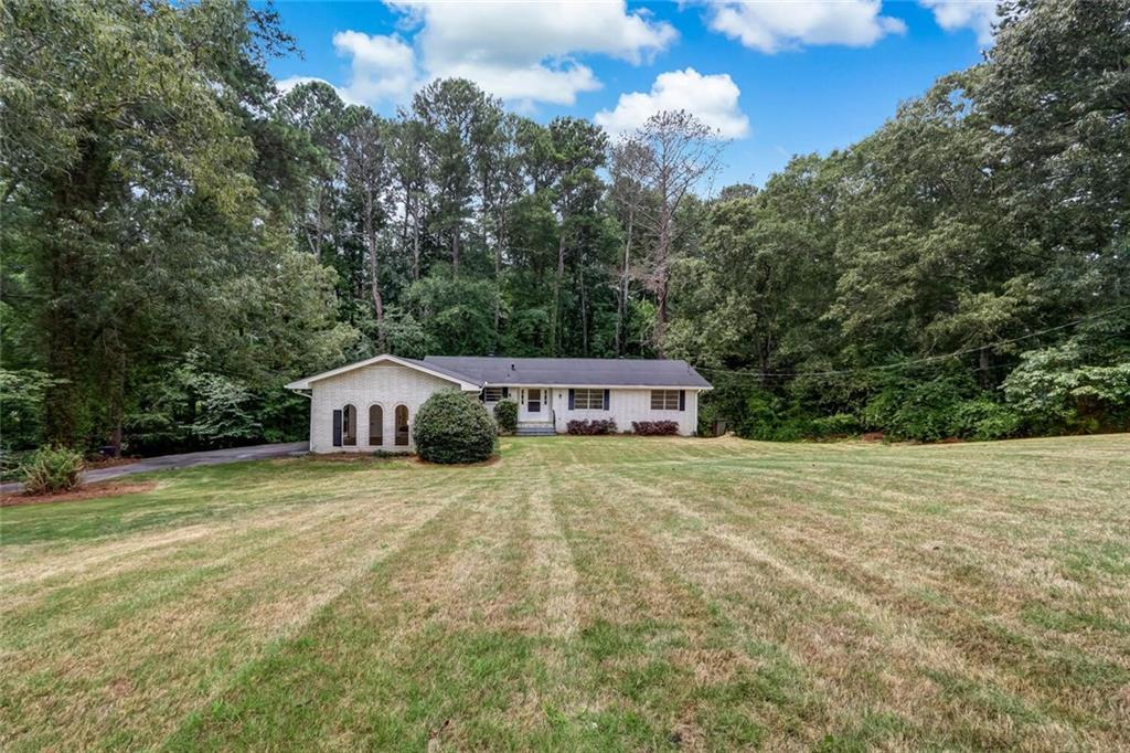 a large house with a big yard and large trees