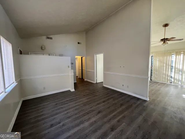 a living room with stainless steel appliances kitchen island granite countertop wooden floor and a window