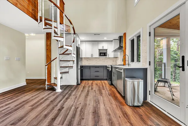 a view of a kitchen with furniture and wooden floor