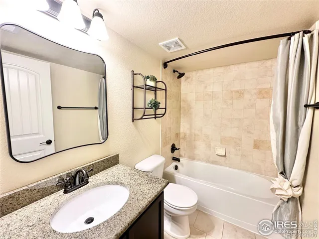 a bathroom with a granite countertop sink toilet a mirror a bathtub and shower