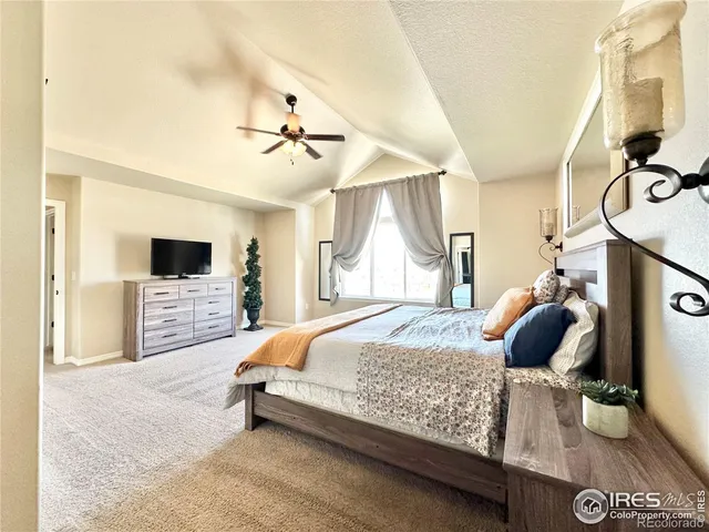 a bedroom with a large bed and a chandelier
