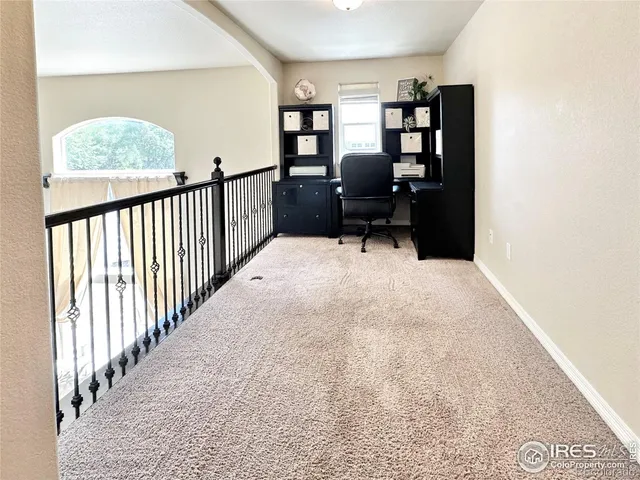 a view of staircase with lots of frames on wall and a large window