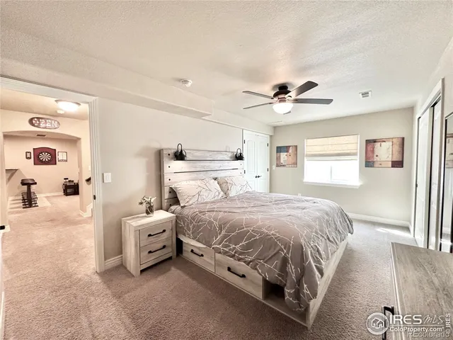 a spacious bedroom with a bed and a ceiling fan