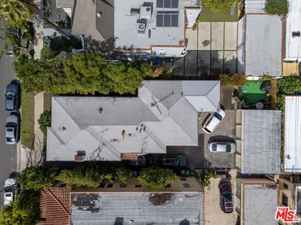 an aerial view of a house with a yard and large tree