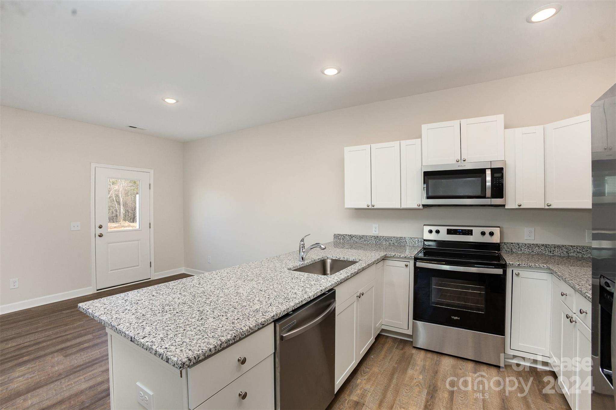 2866 Fay Jones Road Denver, NC 28037 - Photo 3 of 16 a kitchen with granite countertop white cabinets and stainless steel appliances