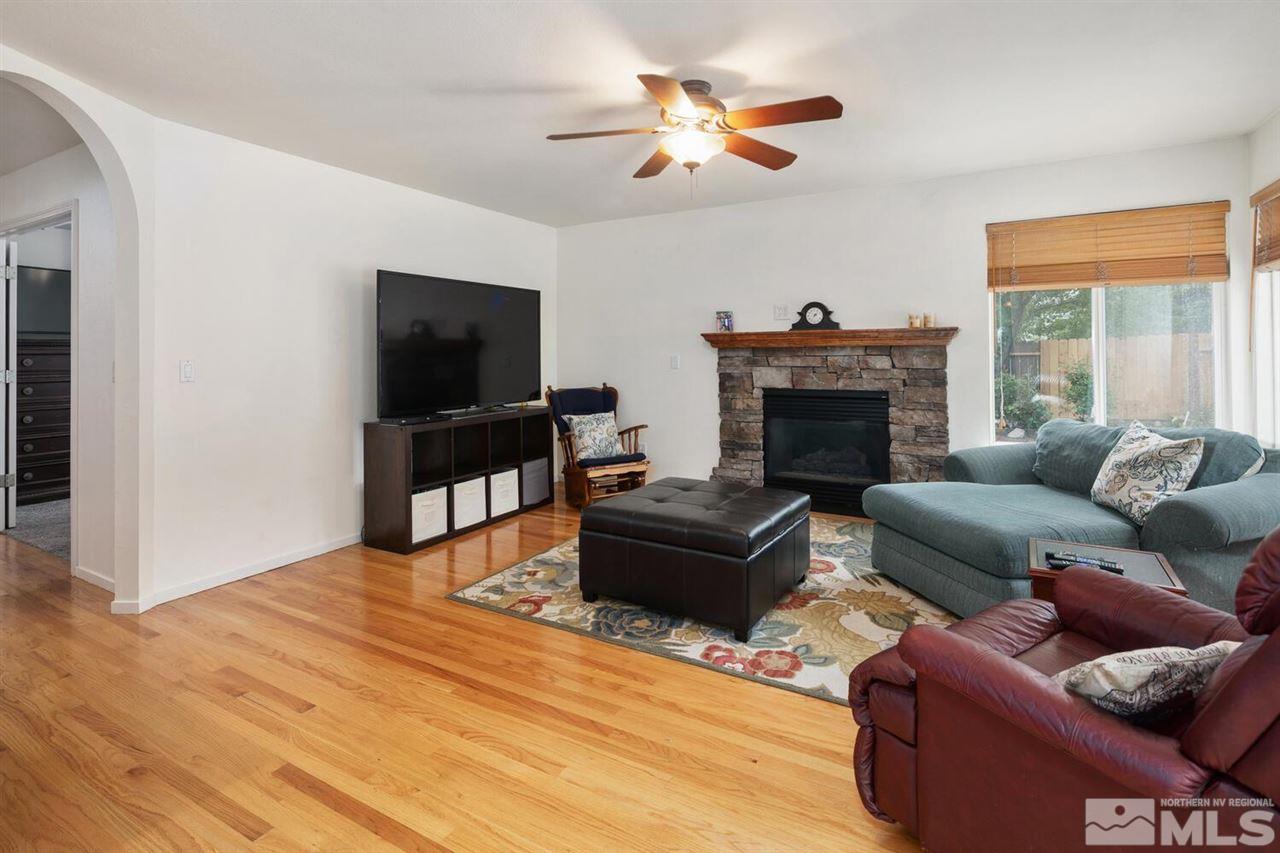14425 Ghost Rider Drive Reno, NV 89511 - Photo 11 of 37 a living room with furniture a fireplace and a flat screen tv
