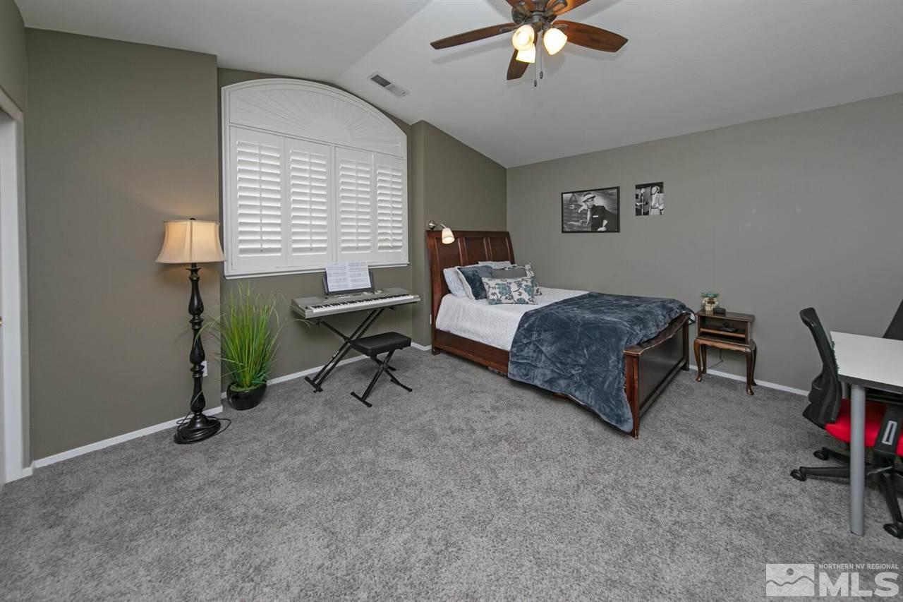 14425 Ghost Rider Drive Reno, NV 89511 - Photo 25 of 37 a bedroom with a bed and a chandelier