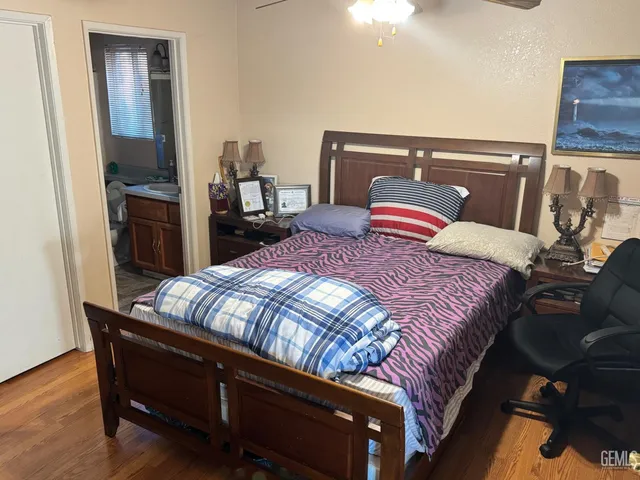 a bedroom with a bed and wooden floor