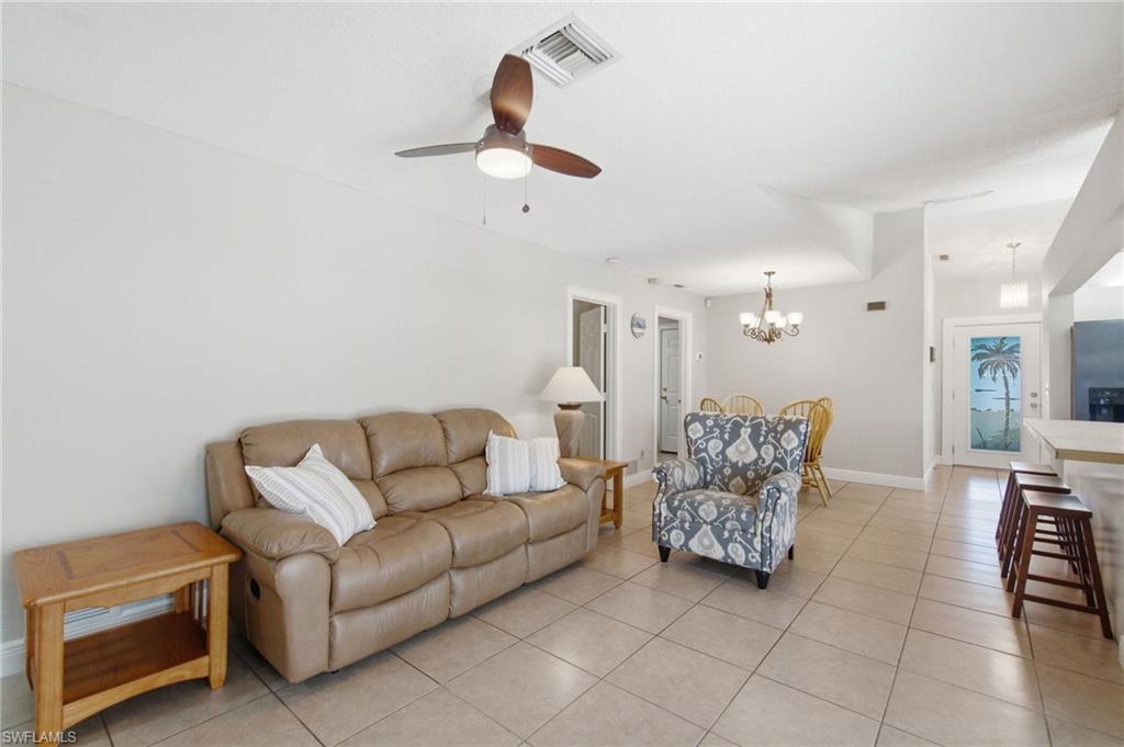 3022 47th Street Southwest Naples, FL 34116 - Photo 21 of 46 Open-concept living space featuring neutral tone walls, square tile flooring, a ceiling fan with integrated lighting, and recessed lighting