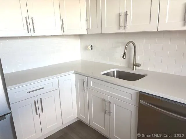 a kitchen with white cabinets and a sink
