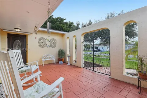 a view of a backyard with furniture and floor to ceiling window