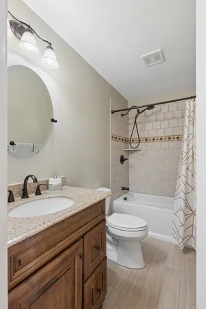 a bathroom with a granite countertop sink toilet a mirror and shower