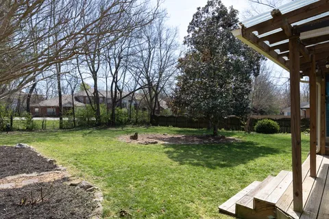 a backyard of a house with lots of green space and fountain