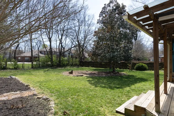 a backyard of a house with lots of green space and fountain