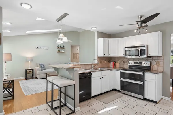a kitchen with stainless steel appliances a stove center island a refrigerator and cabinets