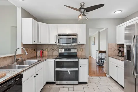 a kitchen with stainless steel appliances a stove sink microwave and cabinets